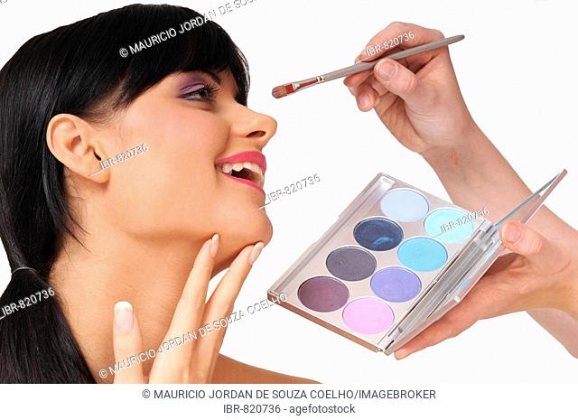Pretty black-haired woman with a fringe, being made-up, make-up, beauty, pink, purple, lipstick, eyeshadow, colours