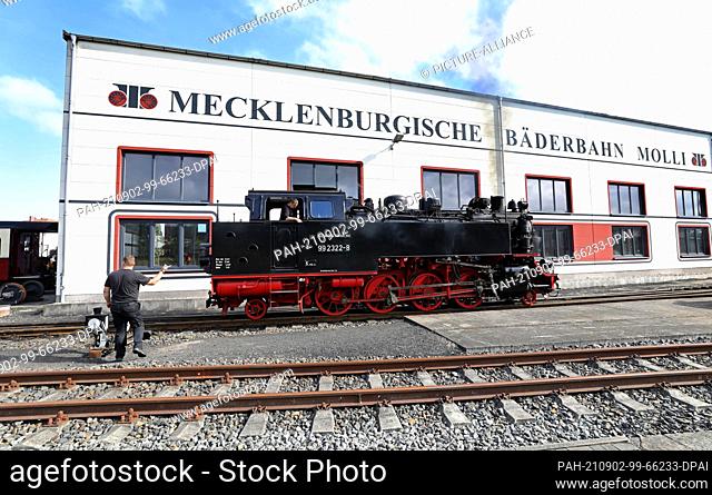 02 September 2021, Mecklenburg-Western Pomerania, Bad Doberan: A locomotive of the Molli narrow-gauge railway shunts in front of the workshop building