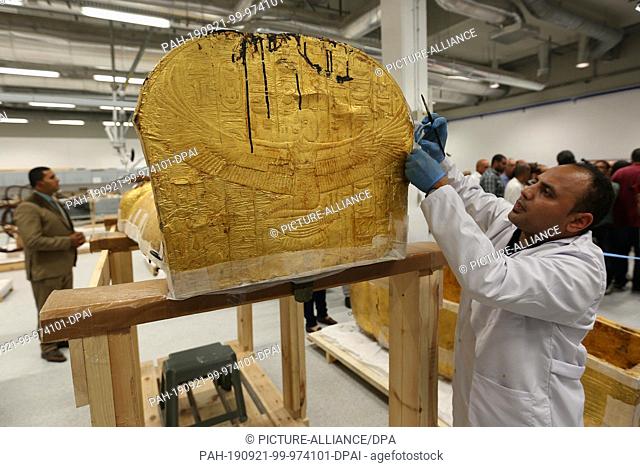 21 September 2019, Egypt, Cairo: An Egyptian archaeologist work on the gilded coffin of King Tutankhamun after it has been out of Sterilization tent to be...