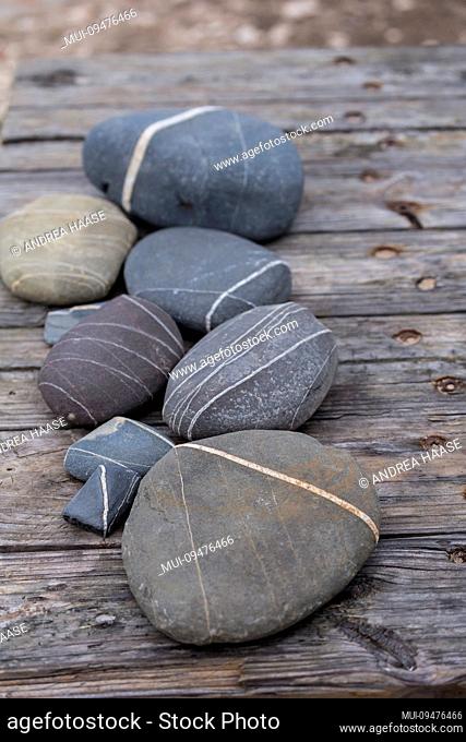 arrangement of pebble with white line on old wooden jetty at the beach