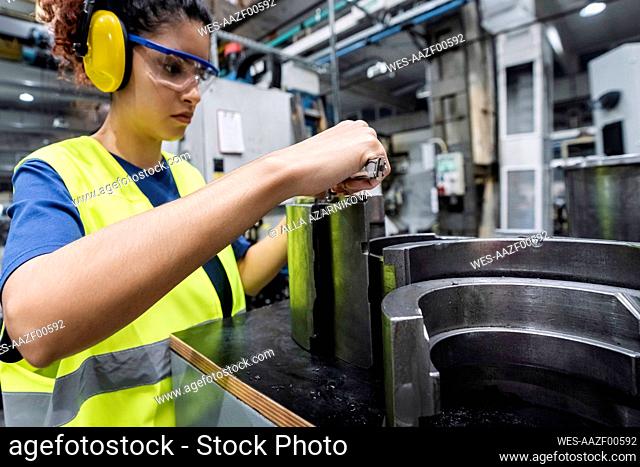 Engineer in protective workwear working in modern manufacturing industry