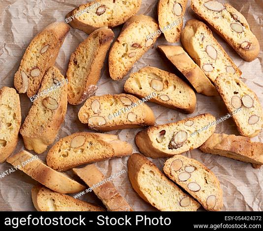 pieces of baked italian christmas biscotti cookies on a brown crumpled paper, top view