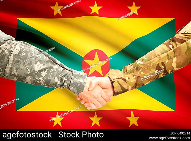 Soldiers shaking hands with flag on background - Grenada