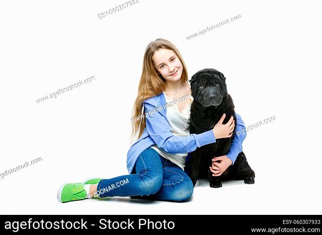 Beautiful smiling teen age girl hugging black shar pei dog. Isolated on white background. Copy space