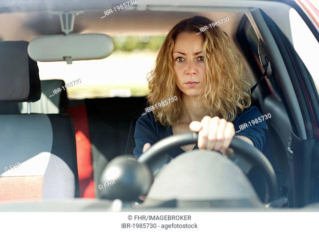 Young woman sitting at the wheel of a car