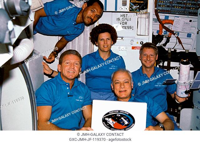On Discovery's middeck, the STS-31 crew poses for a traditional in-flight portrait. Astronaut Loren J. Shriver, mission commander, is at lower left