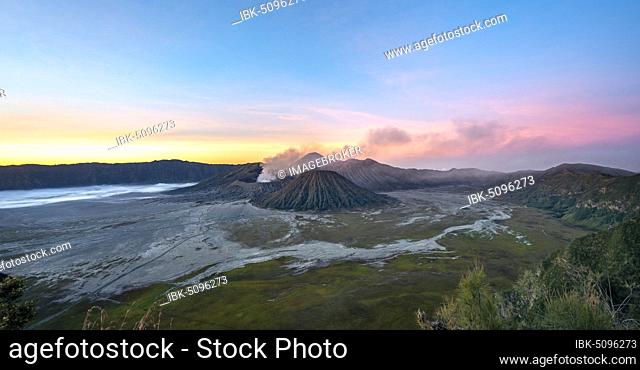 Volcanic landscape at sunrise, smoking volcano Gunung Bromo, with Mt. Batok, Mt. Kursi, Mt. Gunung Semeru, Bromo-Tengger-Semeru National Park, Java, Indonesia