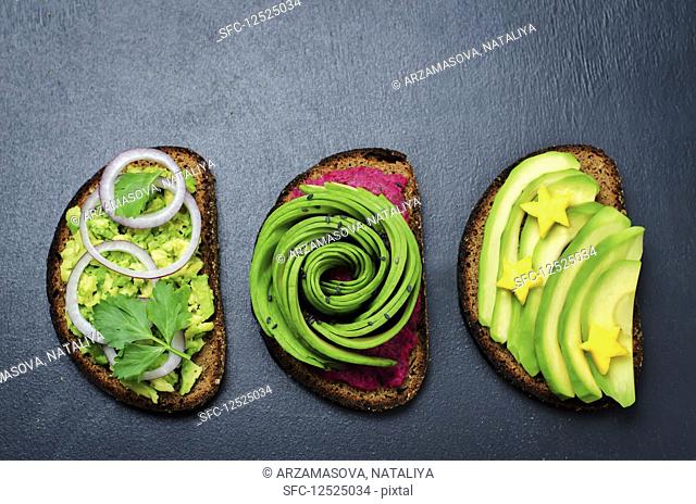 Variation of healthy rye breakfast sandwiches with avocado and toppings. toning