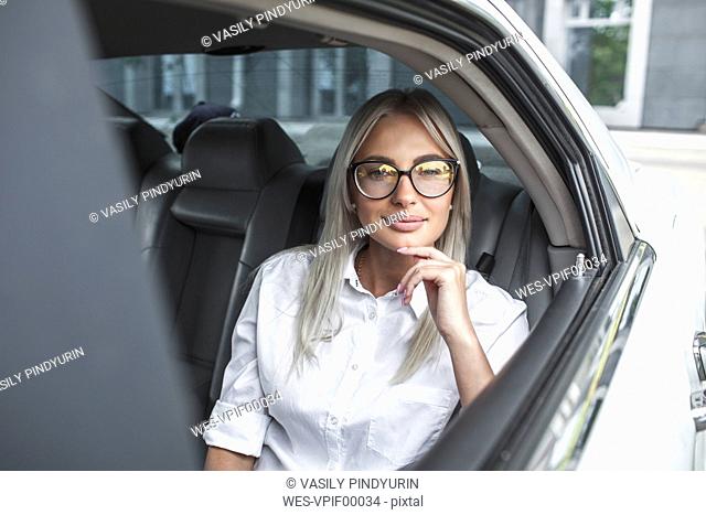 Portait of confident businesswoman with glasses in car