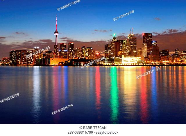 Toronto cityscape panorama at dusk over lake with colorful light