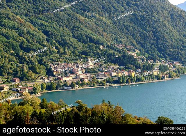 landscape of green lake coast of Como lake with Dorio village, shot in bright fall light from Piona, Lecco, Italy