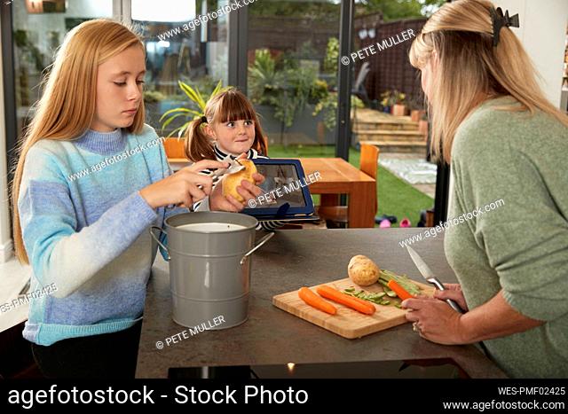 Mother with daughters preparing food at home