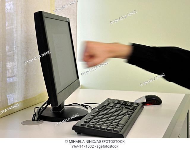 Man`s clenched fist about to hit computer monitor blurred motion