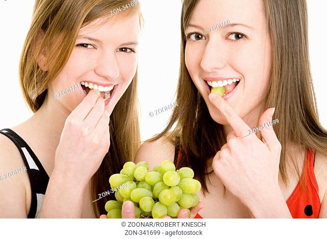 Two women eating grapes