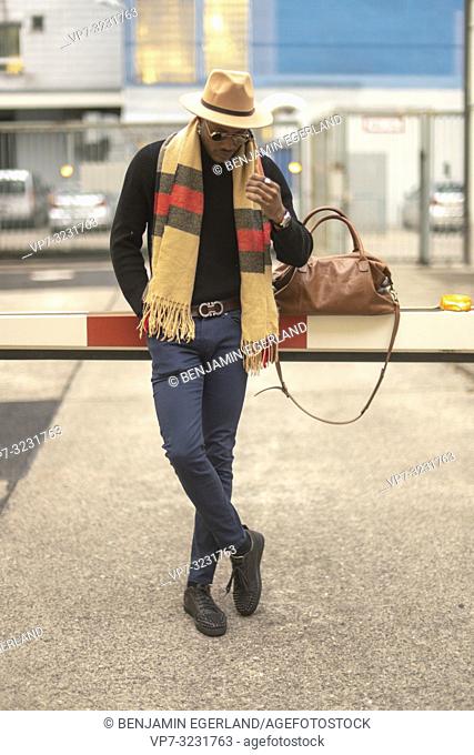 classy man with stylish casual men's fashion outfit, at barrier at industrial area in Munich, Germany