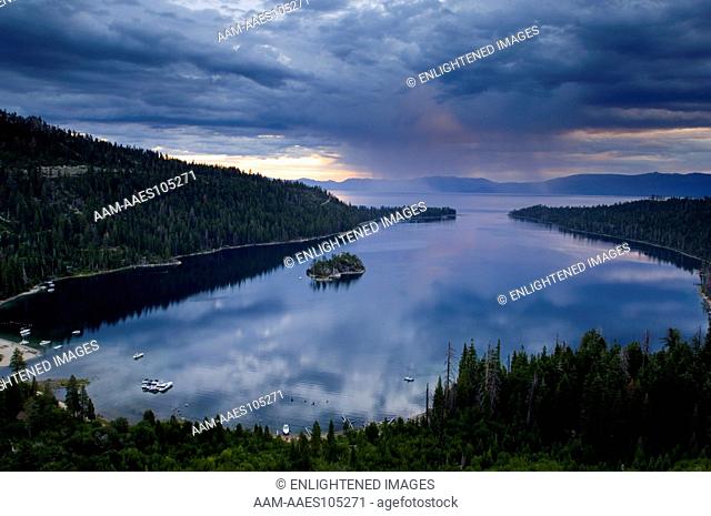 Rain storm clouds at sunrise over the still waters of Emerald Bay State Park, South Lake Tahoe region, California