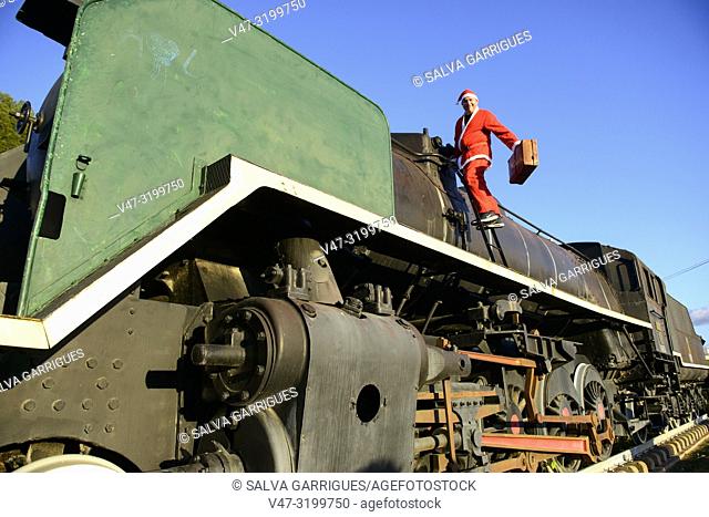 Man disguised as Santa Claus in a steam train locomotive