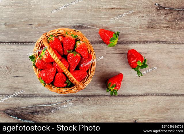 Table top view on small basket full of strawberries on wooden desk