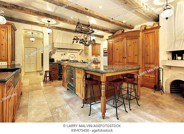 Country kitchen in luxury home with wood ceiling beams