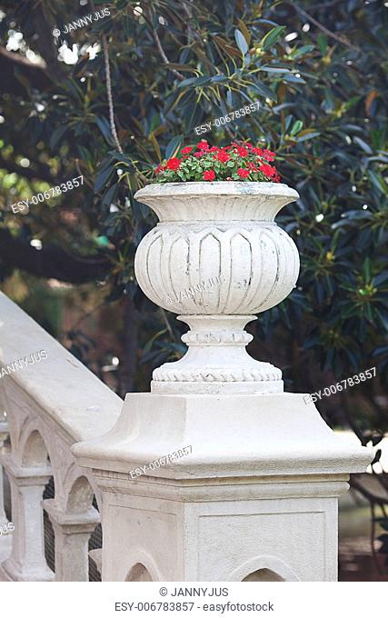 beautiful vase with red flowers on the bridge