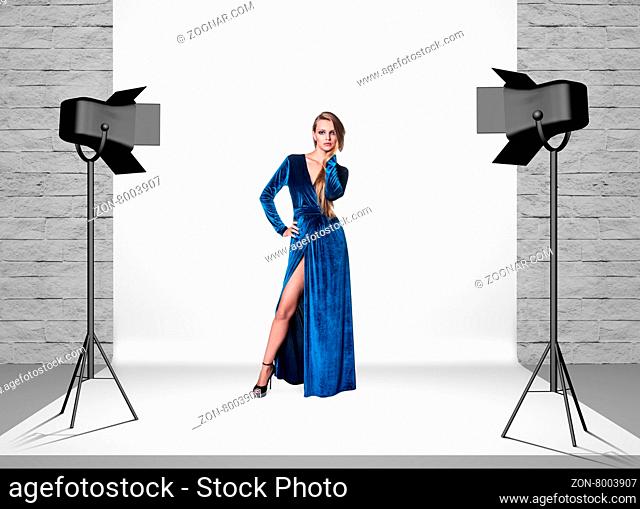 Model in photo studio room with white cloth and spotlights