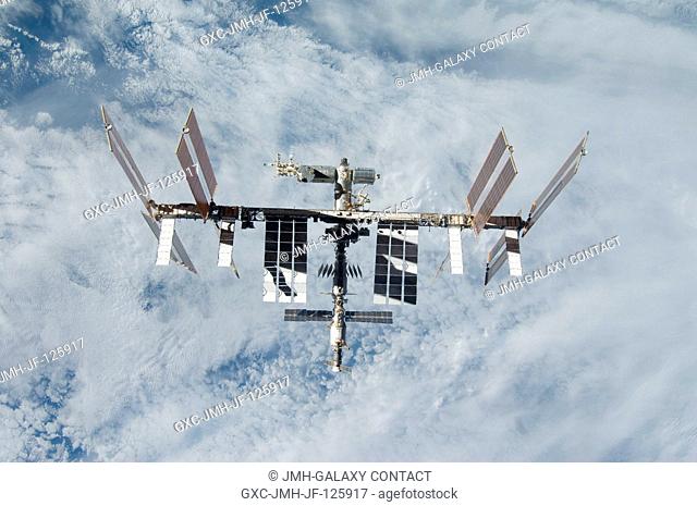 Backdropped by a blue and white part of Earth, the International Space Station is seen from Space Shuttle Discovery as the two spacecraft begin their relative...