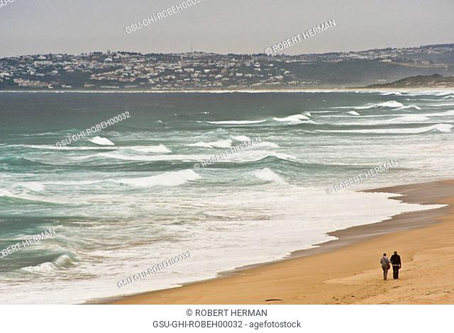 Couple Walking Along Shoreline With Hills in Background, Plettenburg Bay, South Africa