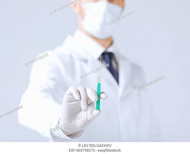 close up of male doctor holding syringe with injection