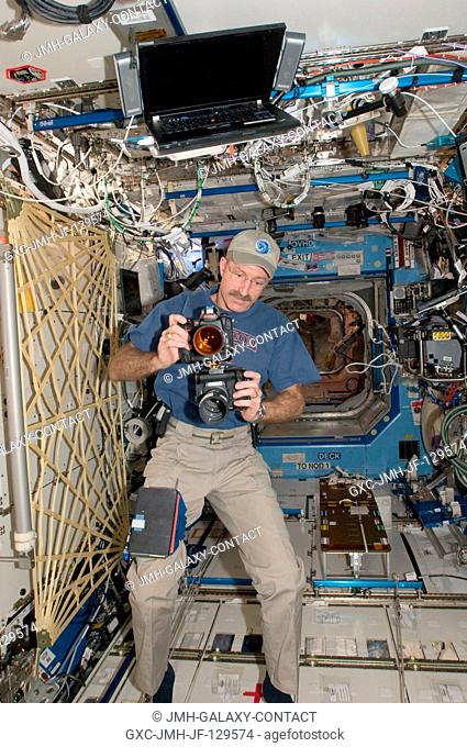 NASA astronaut Dan Burbank, Expedition 30 commander, works with two still cameras mounted together in the Destiny laboratory of the International Space Station