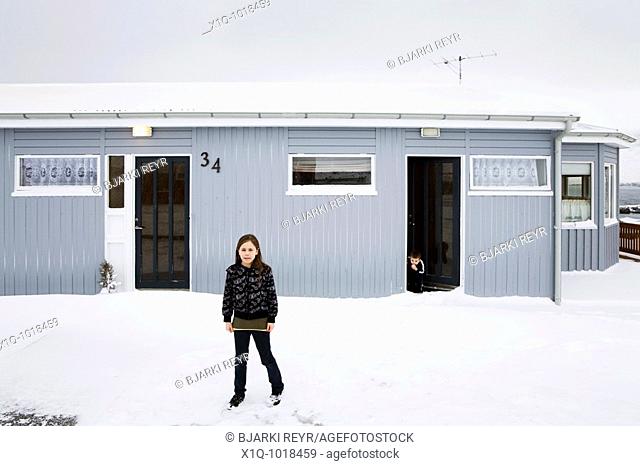 Bryndis 9 standing outside her home, her brother Matthias 2 standing in the doorway  Vopnafjordur, East Iceland  Vopnafjordur hopes to service the oil industry...
