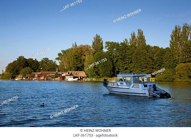 Boathouses and motorboat on lake Schwerin, Schwerin, Mecklenburg Western-Pomerania, Germany