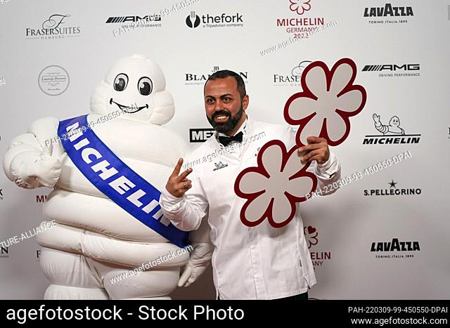 09 March 2022, Hamburg: Two-star chef Edip Sigl of ""Es:senz"" in Grassau, Upper Bavaria, symbolically holds up two stars after the 2022 Michelin Star Awards...