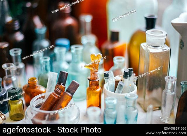Many Old Medical Glass Capacity. Detail Of Retro Chemical Pharmaceutical Science Researches. Many Small Vintage Bottles And Glassware Different Sizes And Colors