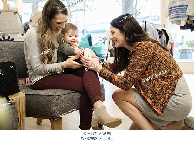 Caucasian women and baby boy shopping in shoe store