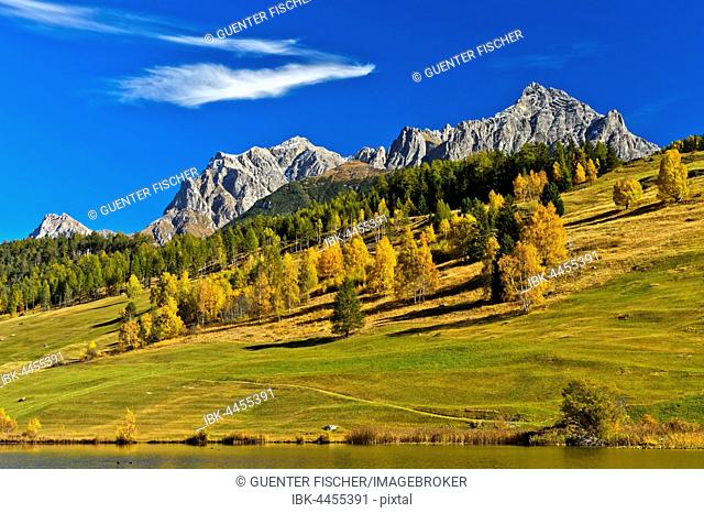 Lai da Tarasp, lake with mountain landscape in autumn, Tarasp, Engadin, Grisons, Switzerland