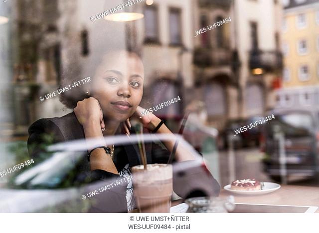 Young woman in a cafe looking out of window