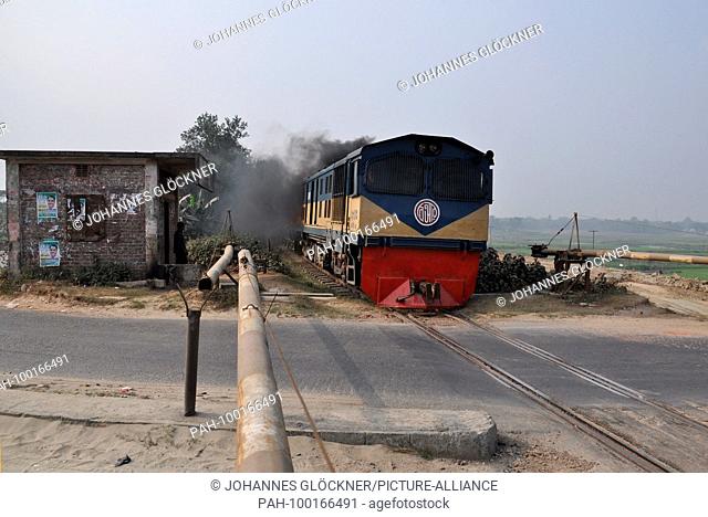 Railroad crossing and train with diesel locomotive 2803 near Narsingdi on 09.01.2015 - Bangladesh. | usage worldwide. - Narsingdi/Dhaka/Bangladesh
