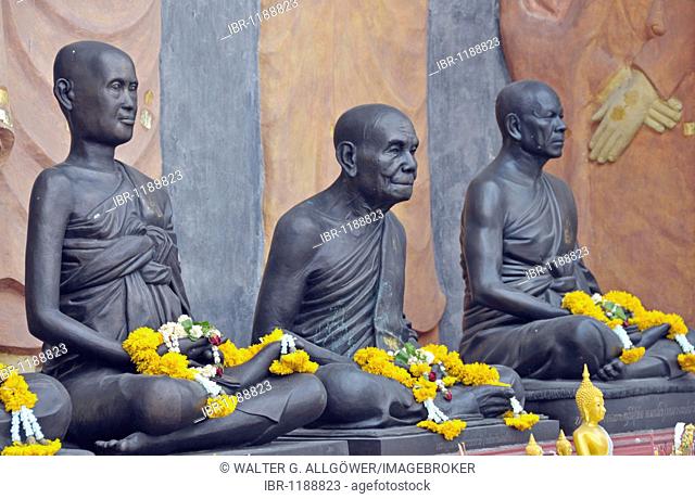 Statues of monks decorated with garlands of flowers, Amulet Market in Bangkok, Thailand, Asia