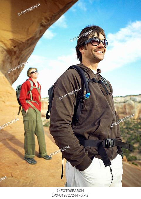 Two men hiking on red rocks