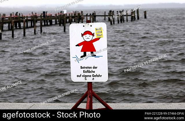28 December 2022, Mecklenburg-Western Pomerania, Rerik: A sign warns against stepping on ice at the churned-up water in the harbor at Salzhaff