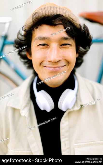 Smiling man with headphones wearing knit hat