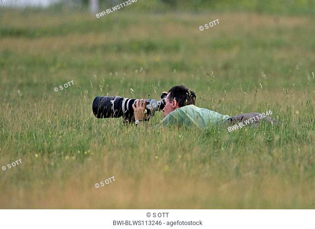 nature fotographer lying in meadow, Austria