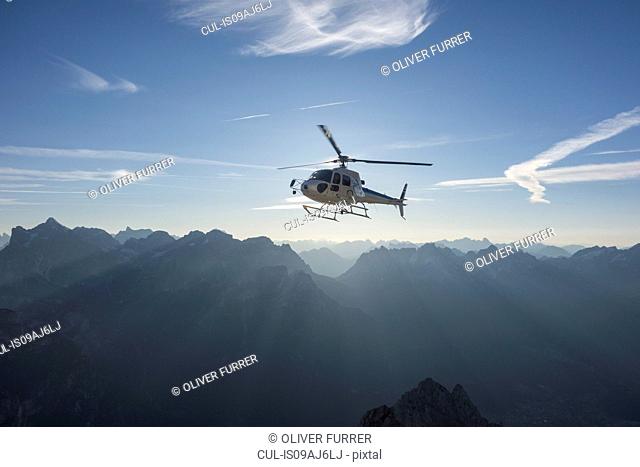 Helicopter on scenic flight at sunrise, Alleghe, Dolomites, Italy