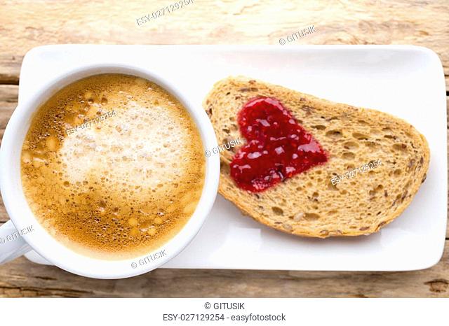 Fresh coffee. Grain slice of bread with jam heart shape