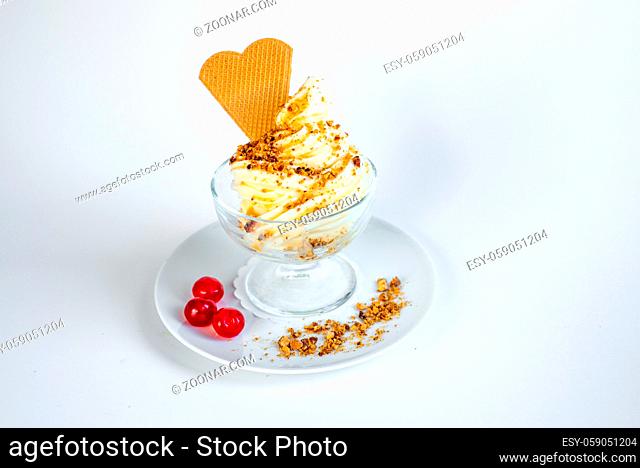 on a white base there is a sundae with vanilla ice cream and sauce and cherries