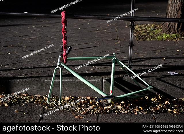 07 November 2023, Saxony, Dresden: Only the frame of a bicycle hangs on a chain lock on a fence. Photo: Robert Michael/dpa. - Dresden/Saxony/Germany