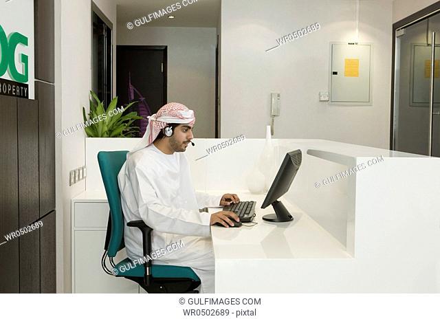 Arab man with headphones, sitting at the office