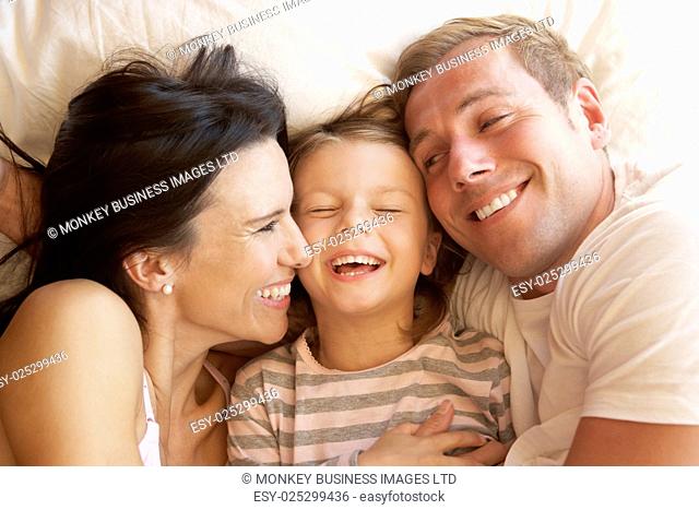 Family Relaxing In Bed