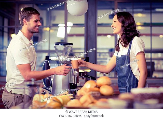 Pretty smiling barista serving a customer