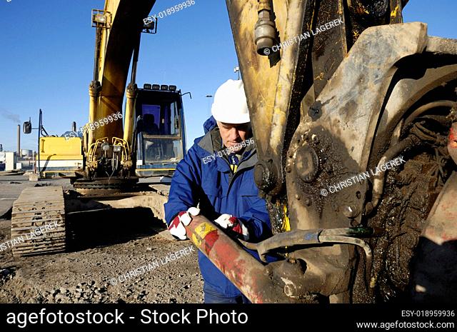 bulldozer being repaired by mechanic worker